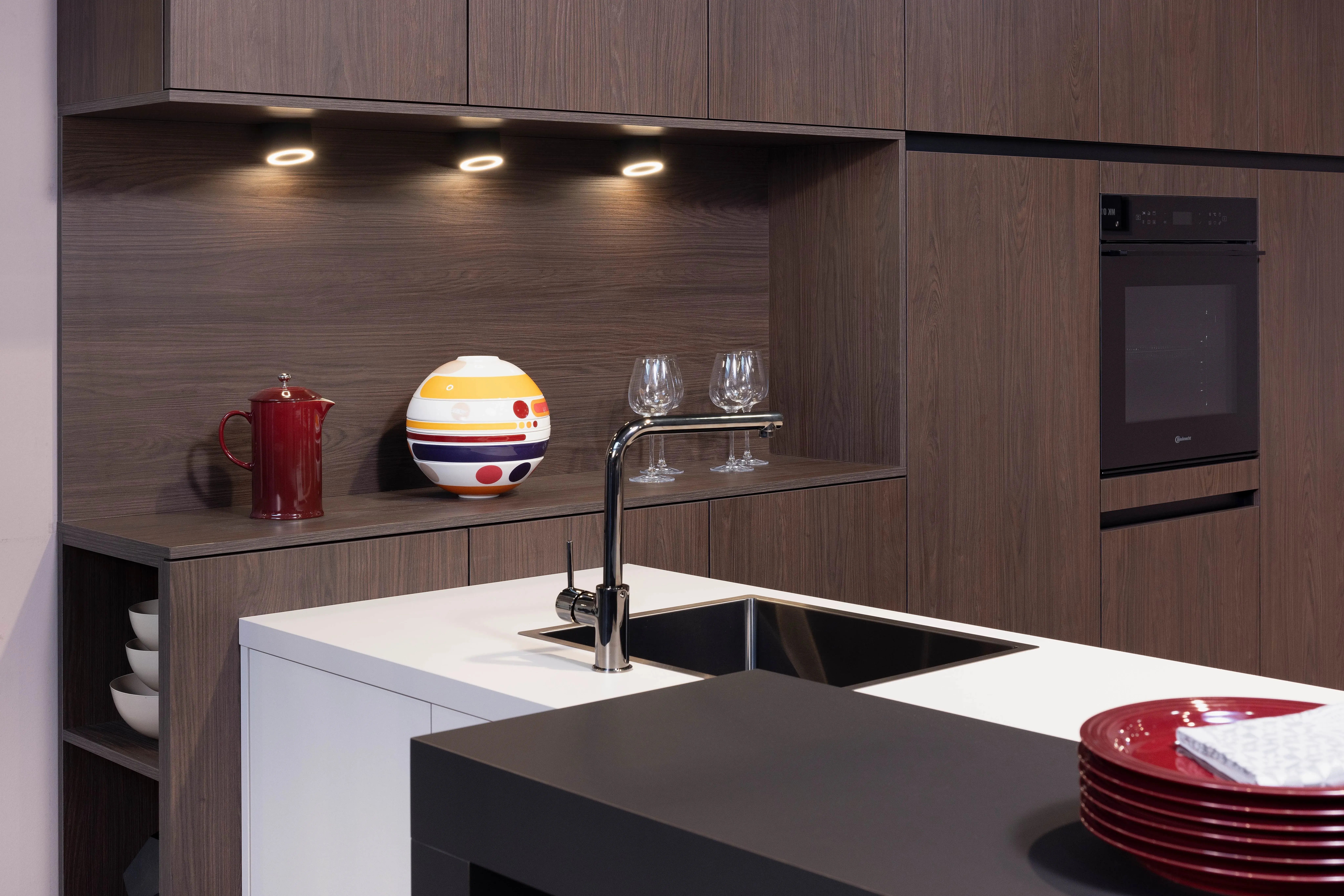 APL:Kashmir und Schwarz Front: Feel Kashmir Front: Casella Dark Oat Korpus: Graphit  Griff: Grifflos Kashmir Geräte: Bauknecht Armatur: Ukinox Spüle: Ukinox  Features: Seitenschränke mit 152 cm Fronthöhe, Kühlschrankumbau für 140 cm Nische, Griffleistenbeleuchtung,  Thekenlösung, Downlights in Regalnische, Spüle in Titaniumoptik