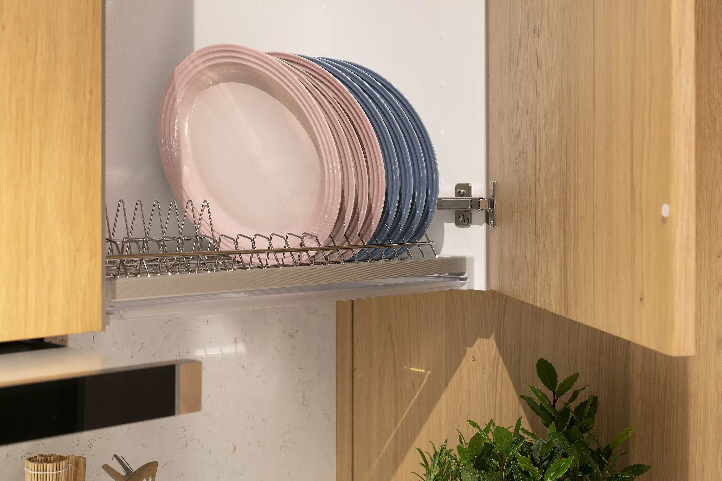 Geöffneter Küchen-Hängeschrank mit Abtropfgestell und Tellern darauf